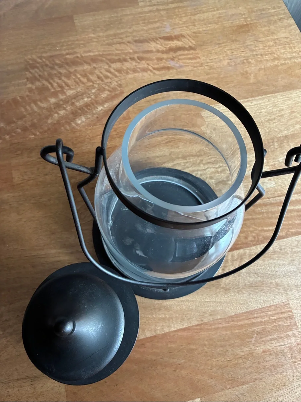 Decorative black metal hurricane lantern/candle lantern. It has a clear glass